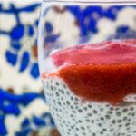 alt="chia seed pudding topped with strawberry sauce served in a glass."