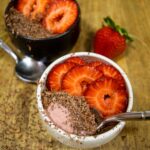 alt="individual portions of strawberry mousse topped with dark chocolate shavings and sliced fresh strawberries."