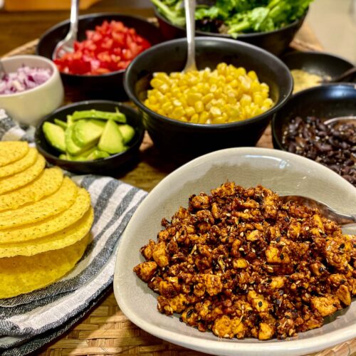 alt="mexican tofu together with other taco fillings like tomatoes, lettuce, red onion, black beans, avocado, and sweet corn."