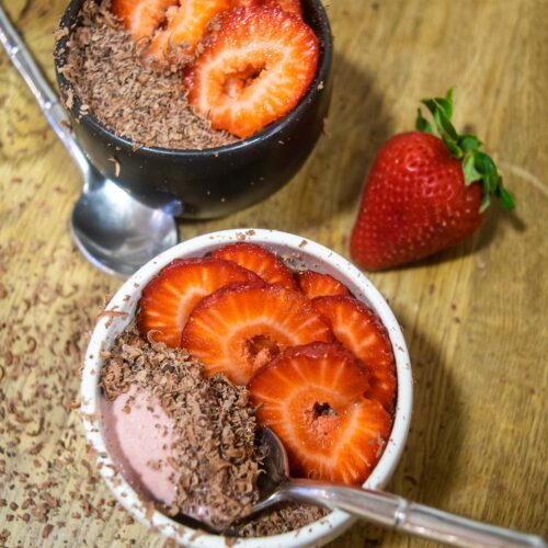 alt="individual portions of strawberry mousse topped with dark chocolate shavings and sliced fresh strawberries."