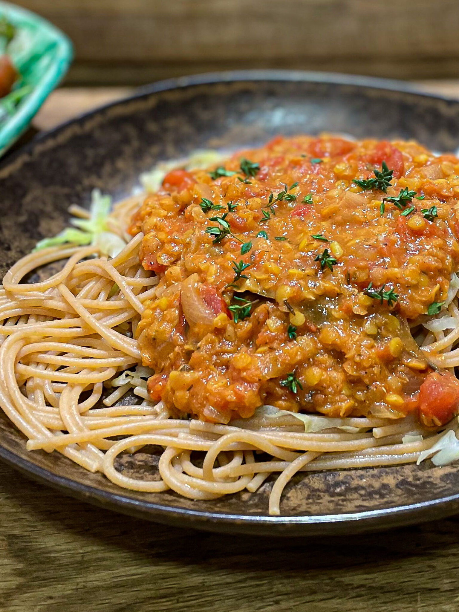 alt="red lentil Bolognese sauce over whole wheat spaghetti."