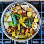 alt="a pot full of the ingredients needed to make homemade vegetable stock ready to go on the stove."
