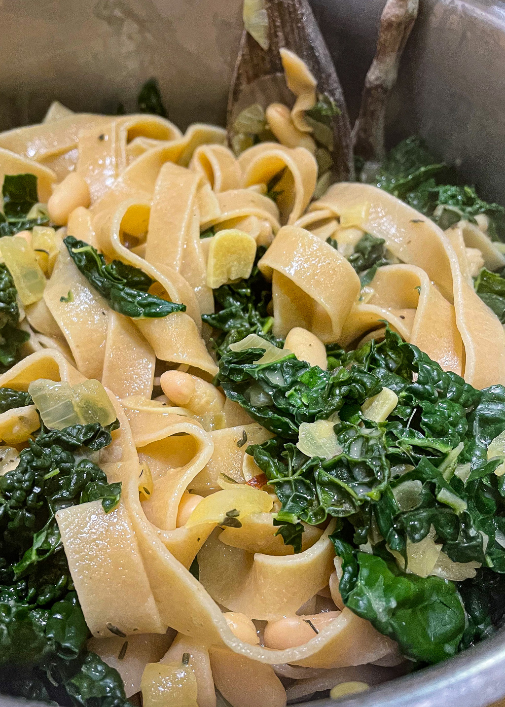alt="a close up of some white beans and kale pasta."