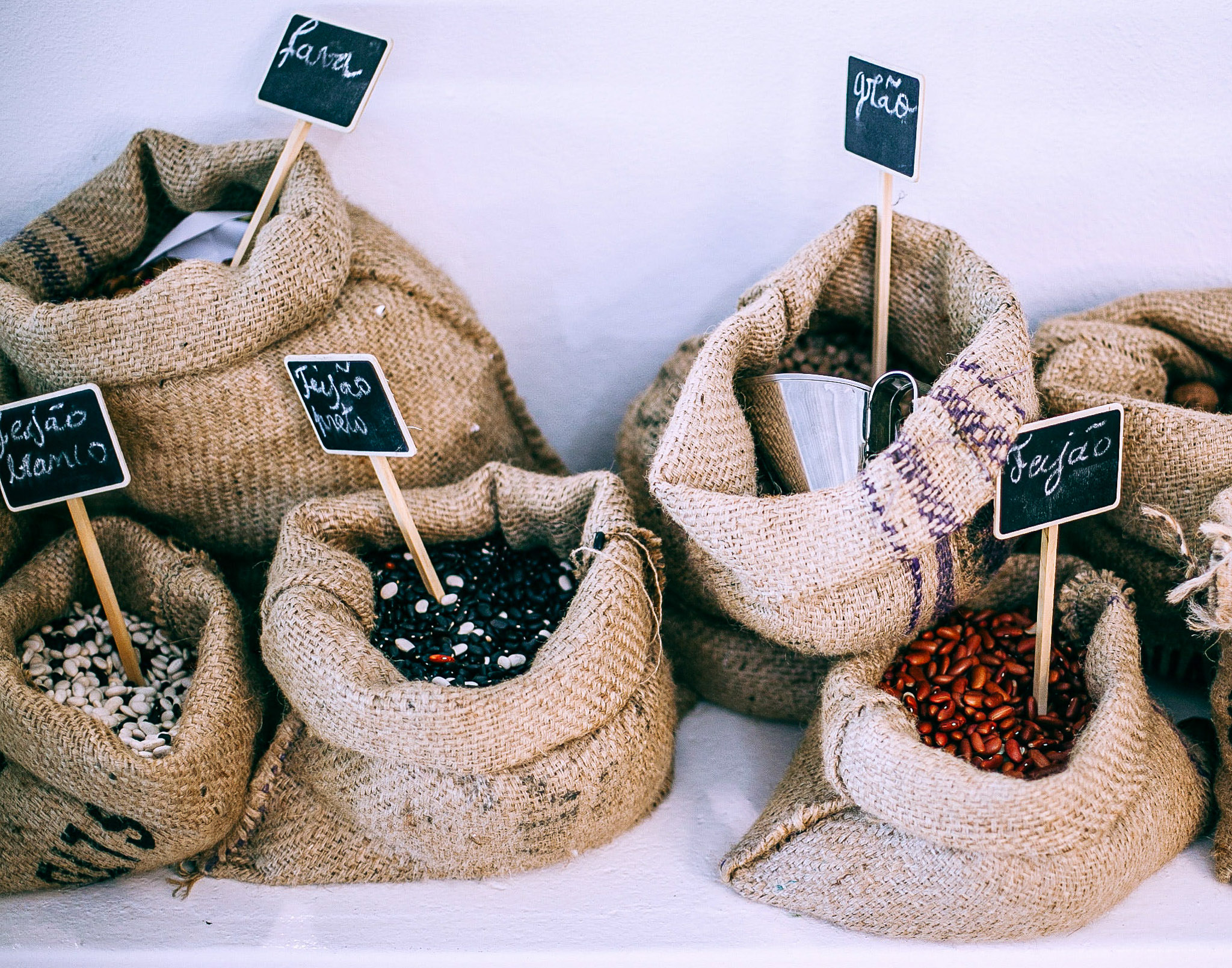 alt="five burlap bags with five different types of dried beans."