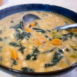 alt="a bowl of white beans and kale soup."