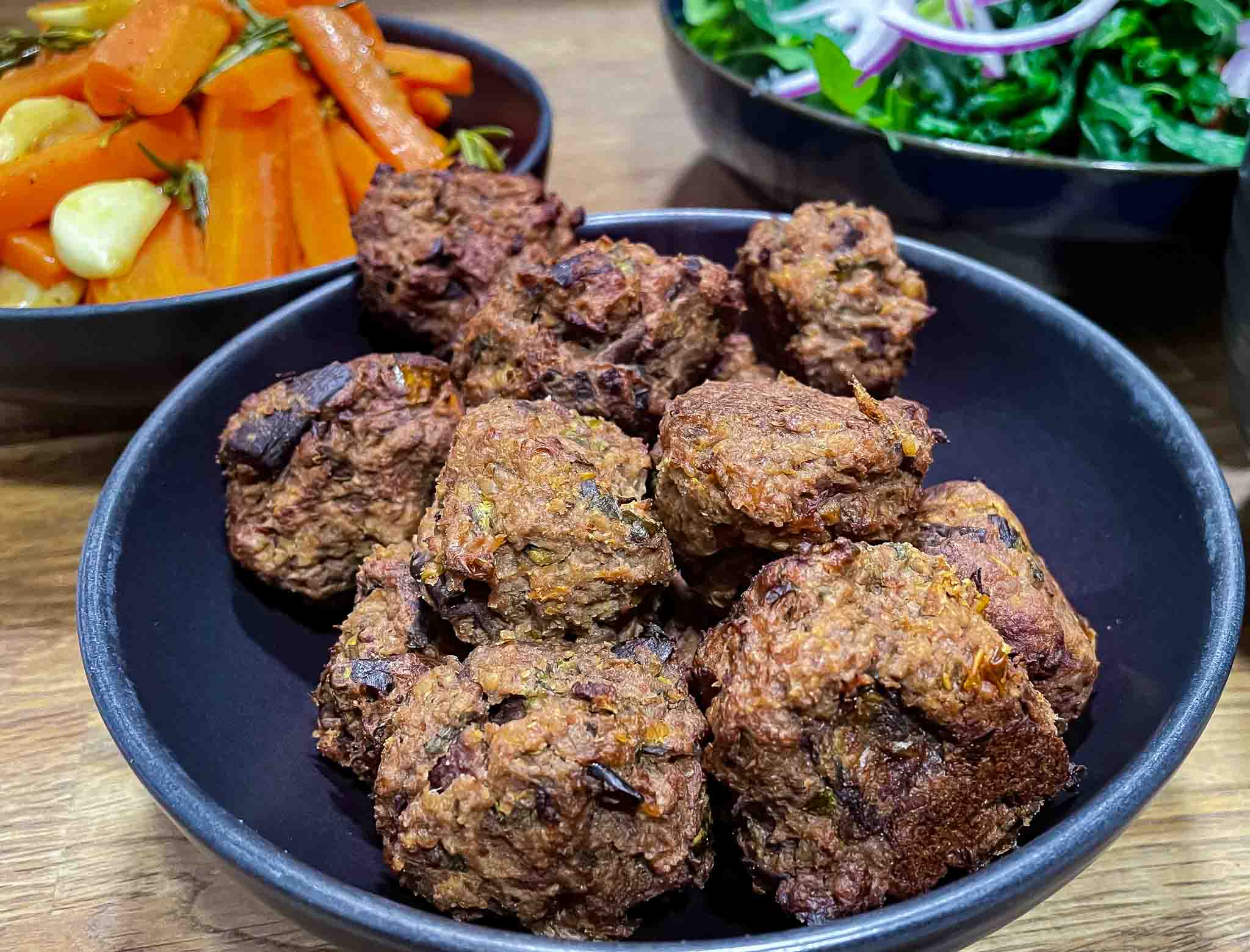 alt="Aubergine Meatballs served with mixed salad and rosemary carrots."