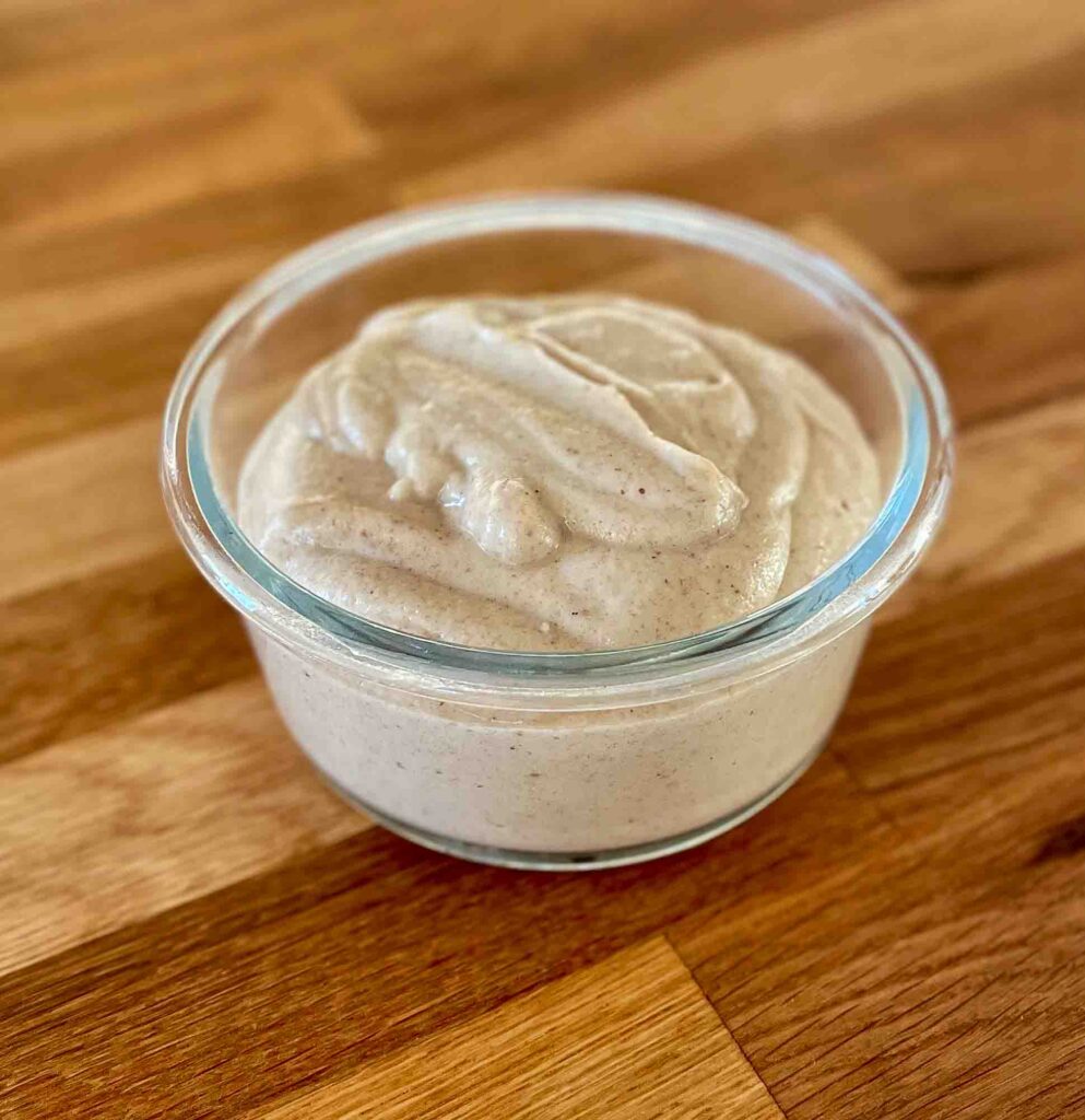 alt="a thick and rich looking cashew nut cream sauce in a glass bowl."
